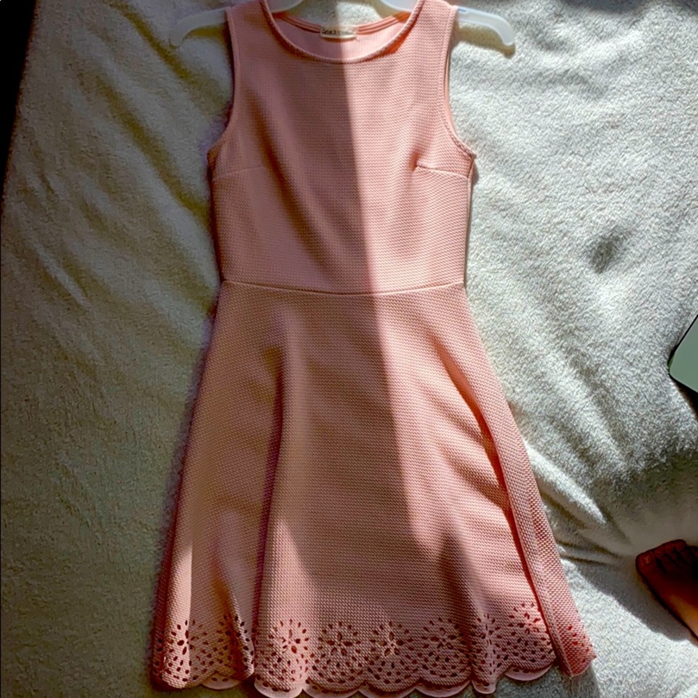 A pale pink strapped, thigh length dress